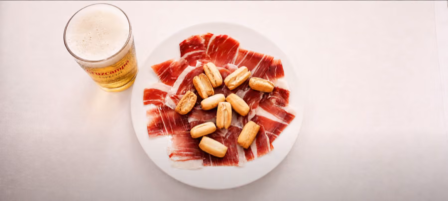 Plate of jamón with a Cruzcampo beer at Feria de Sevilla, still from the commercial