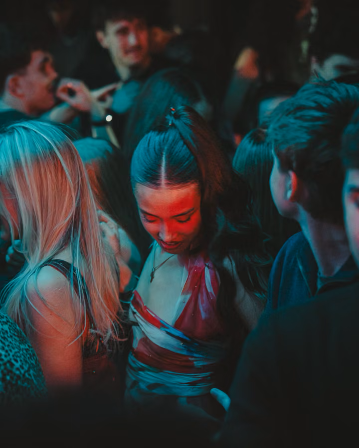 Guests dancing close together under red and teal lighting at Latin Fest, Edinburgh